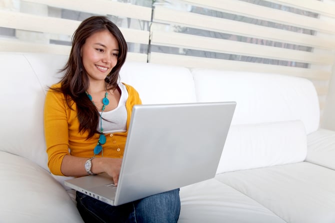 Beautiful woman sitting on the sofa with a laptop